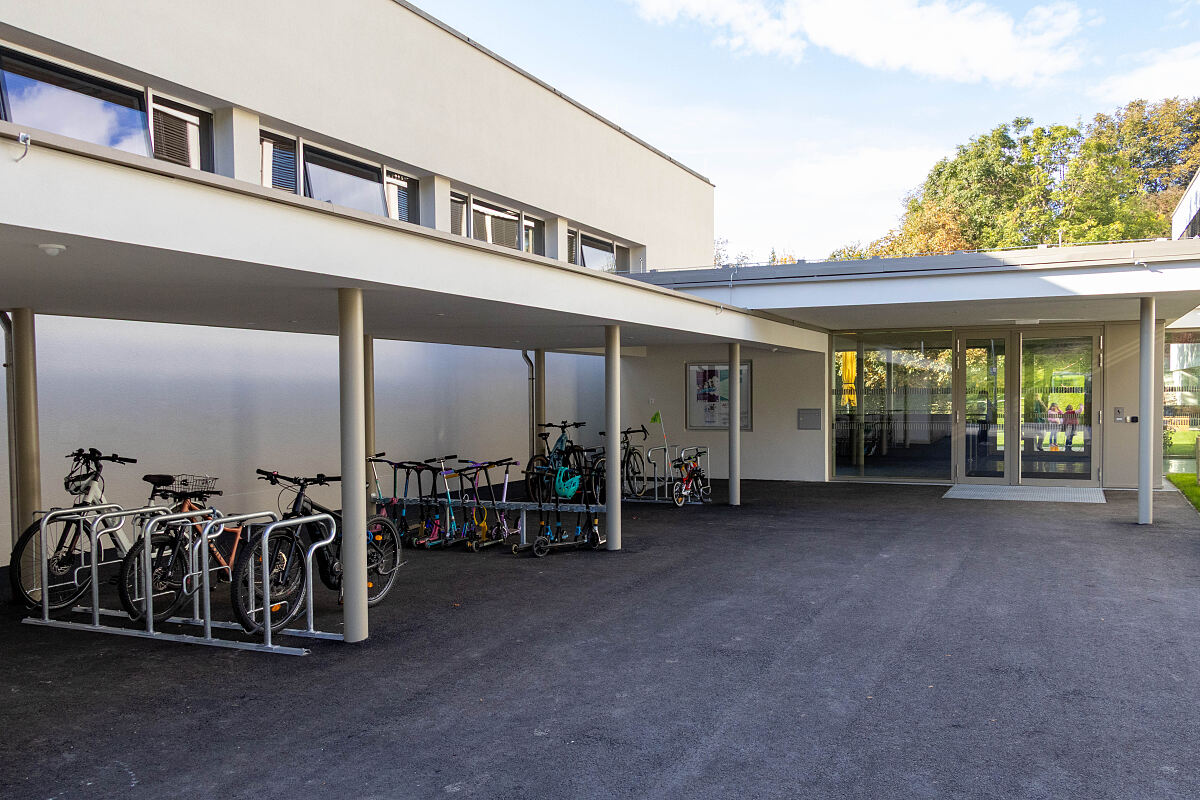 Auch der Eingangsbereich wurde mit einem großen Vorplatz und überdachten Rad- und Rollerabstellmöglichkeiten aufgewertet.
